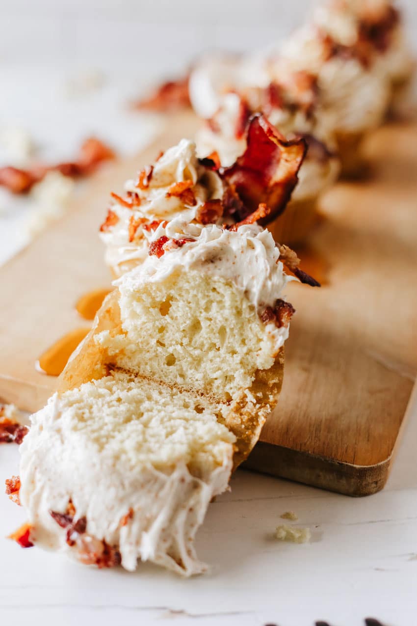 a maple bacon pancake muffin cut in half and resting on a wooden cutting board