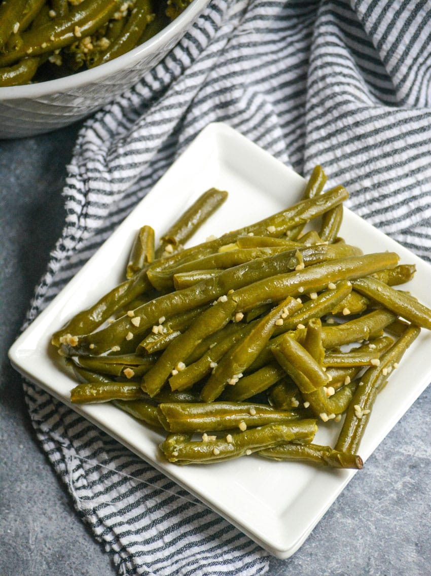 a serving of instant pot garlic green beans on a small white square plate