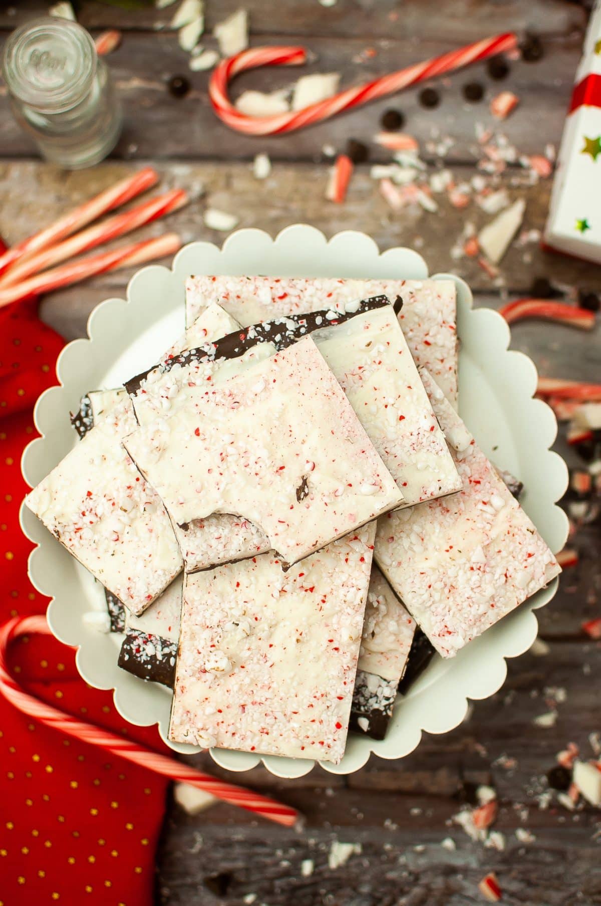 squares of homemade peppermint bark stacked on a white cake stand