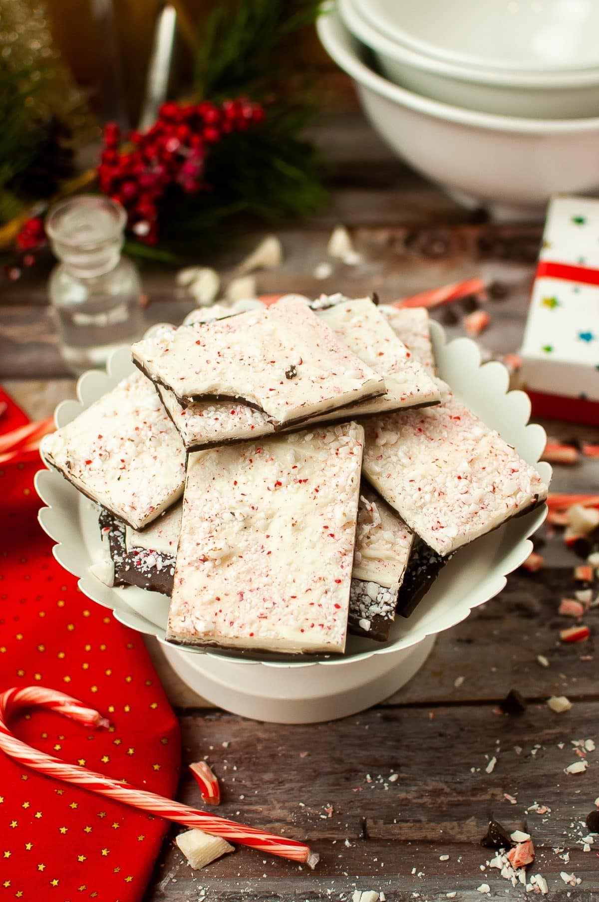 squares of homemade peppermint bark stacked on a white cake stand