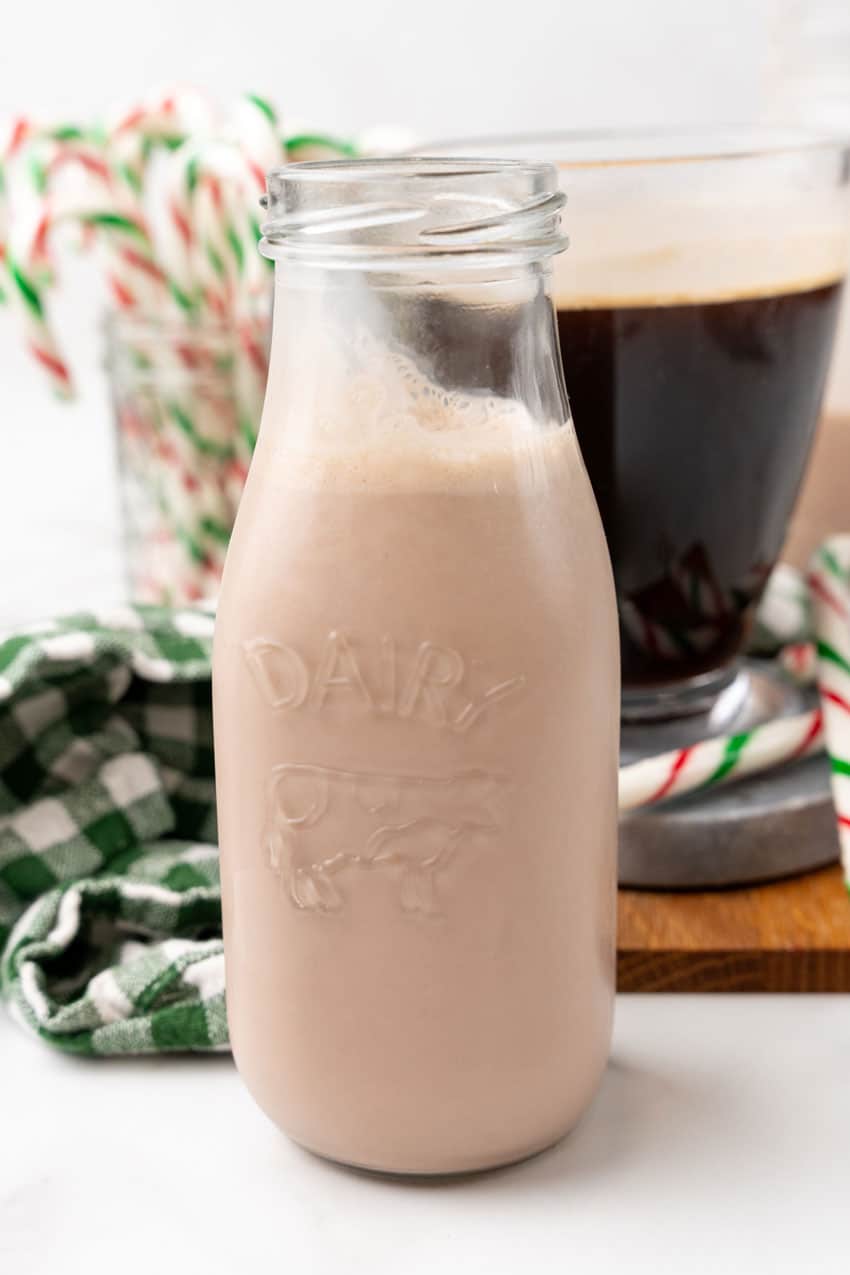 homemade peppermint patty coffee creamer in a small glass jar surrounded by candy canes
