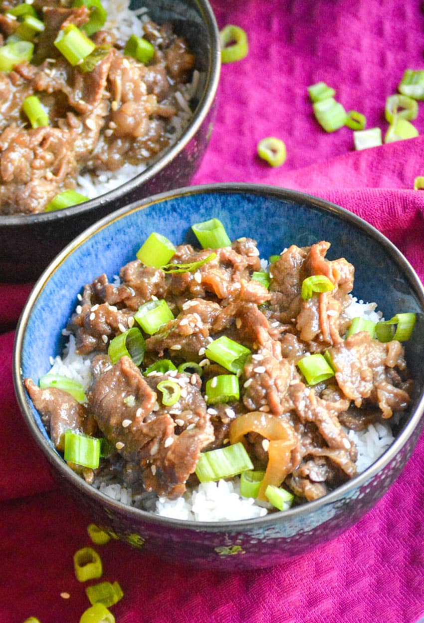 easy beef bulgogi recipe served over steamed white rice in two small blue bowls