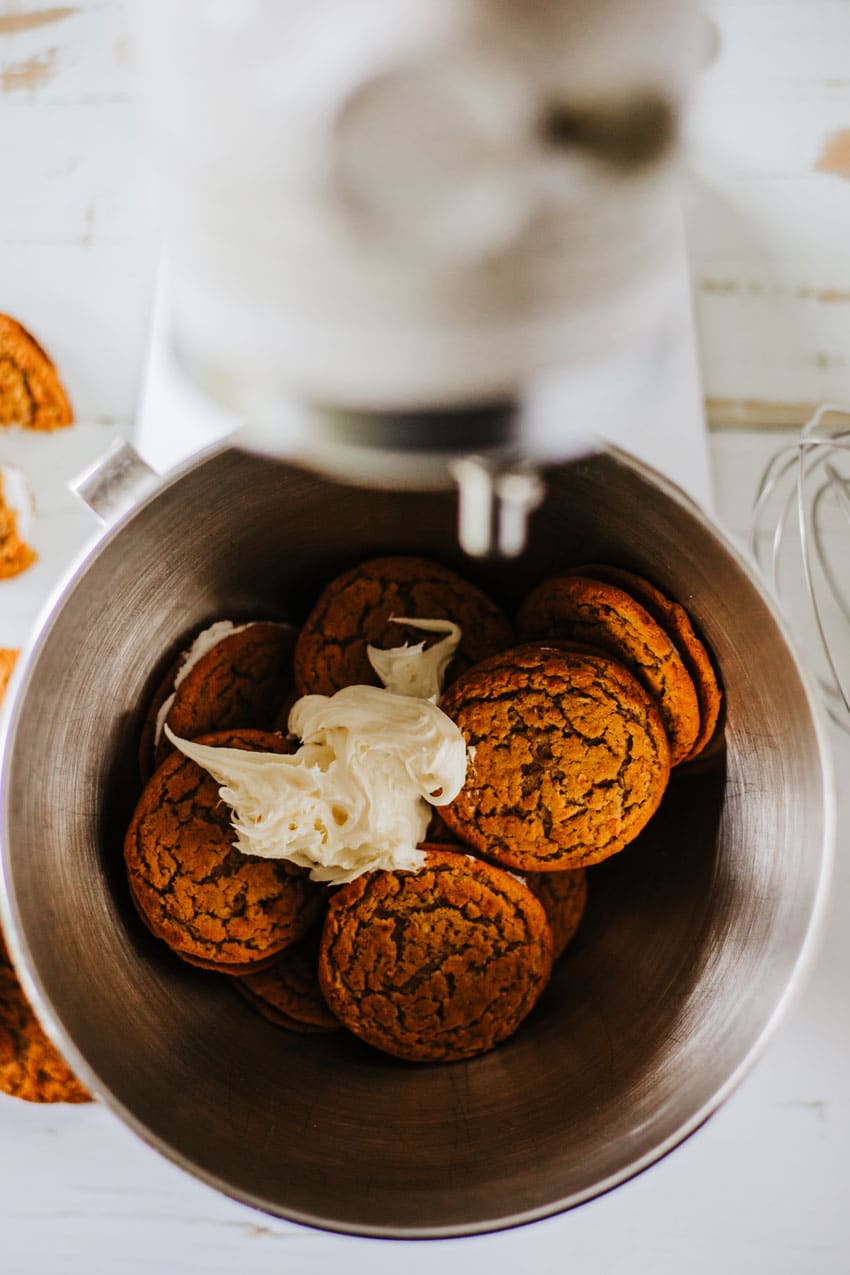 oatmeal cream pies and scoop of cream cheese frosting in the bowl of a stand mixer