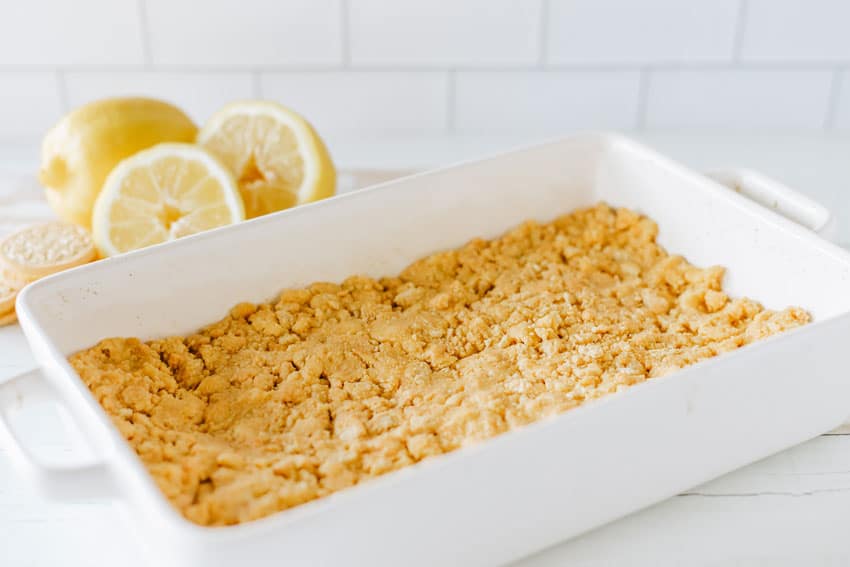 crushed golden oreo crust in the bottom of a white baking dish
