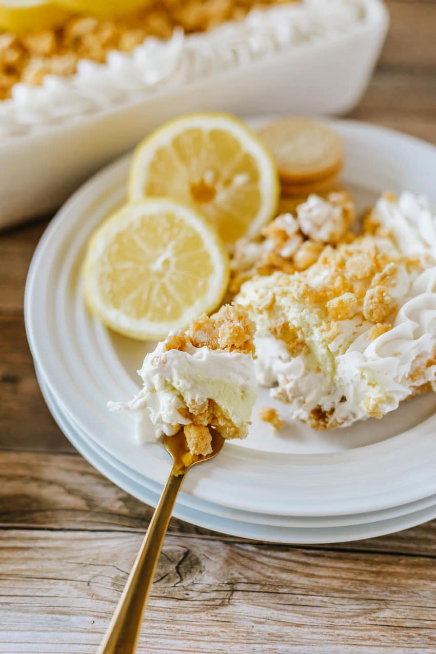 a golden fork holding up a scoop of lemon oreo lasagna