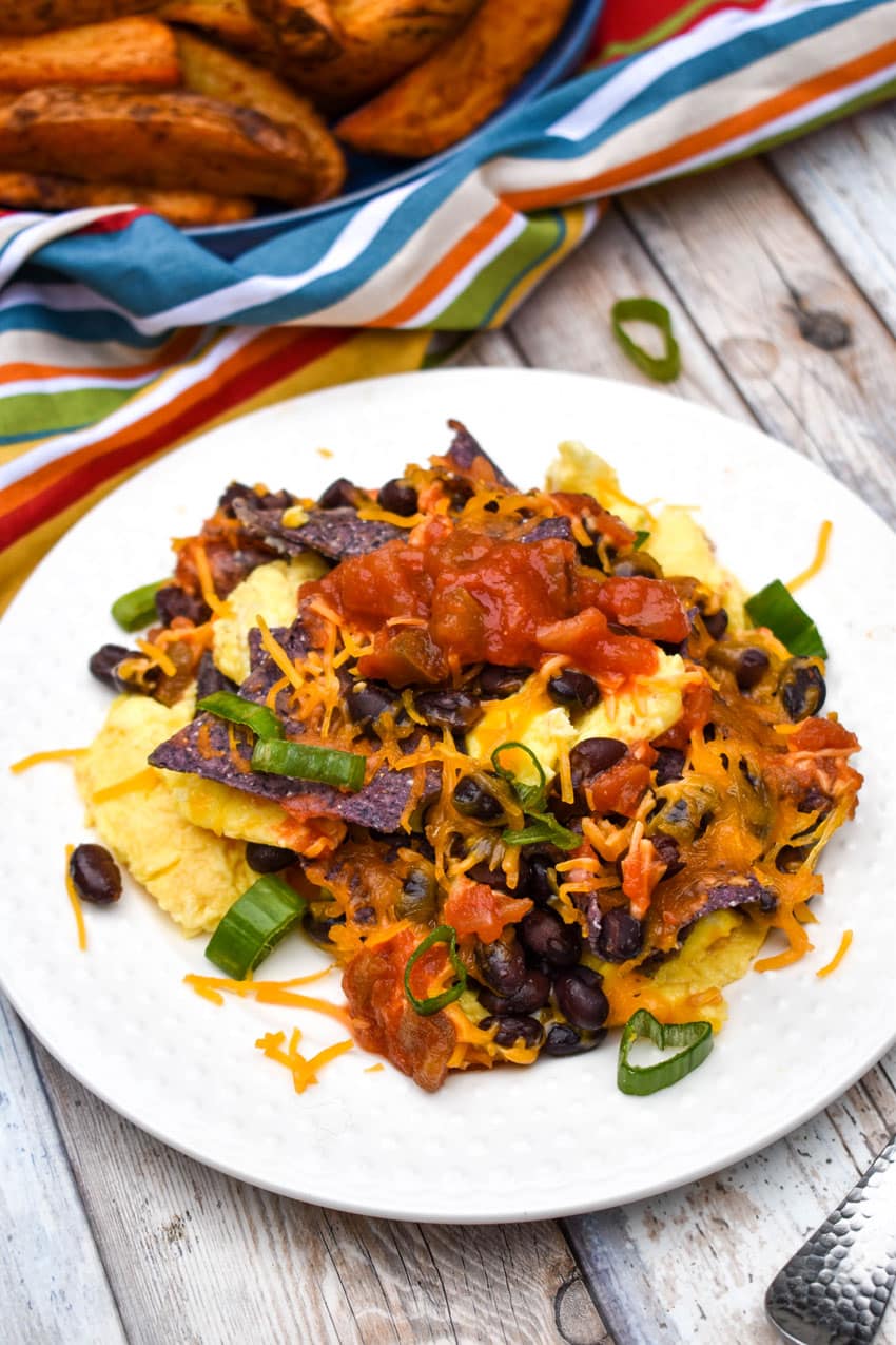 southwestern egg scramble on a small white plate on a wooden table