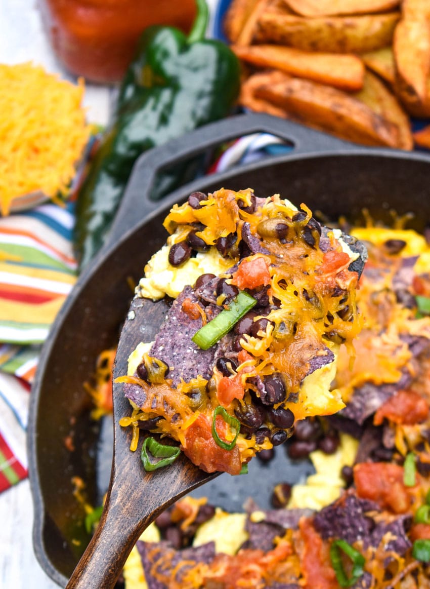 a wooden spatula holding up a scoop of southwestern egg scramble