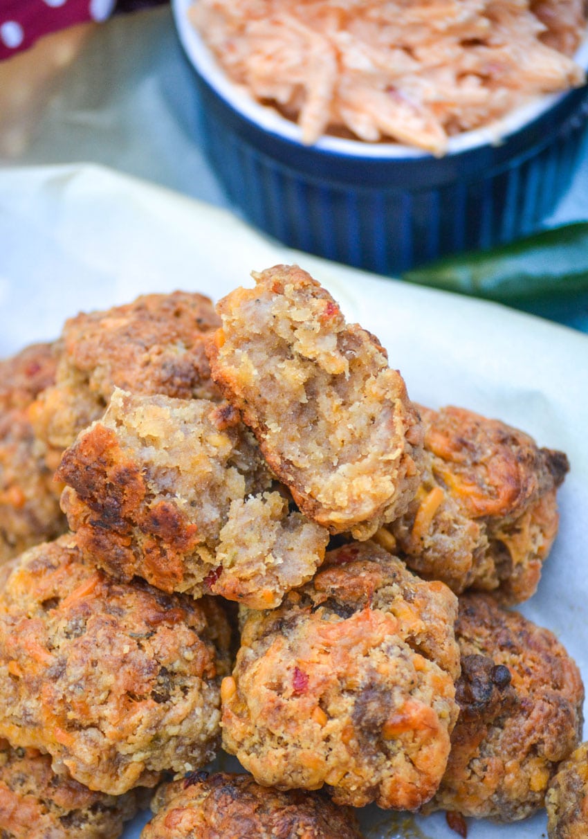 spicy pimento cheese sausage balls piled on a parchment paper lined platter