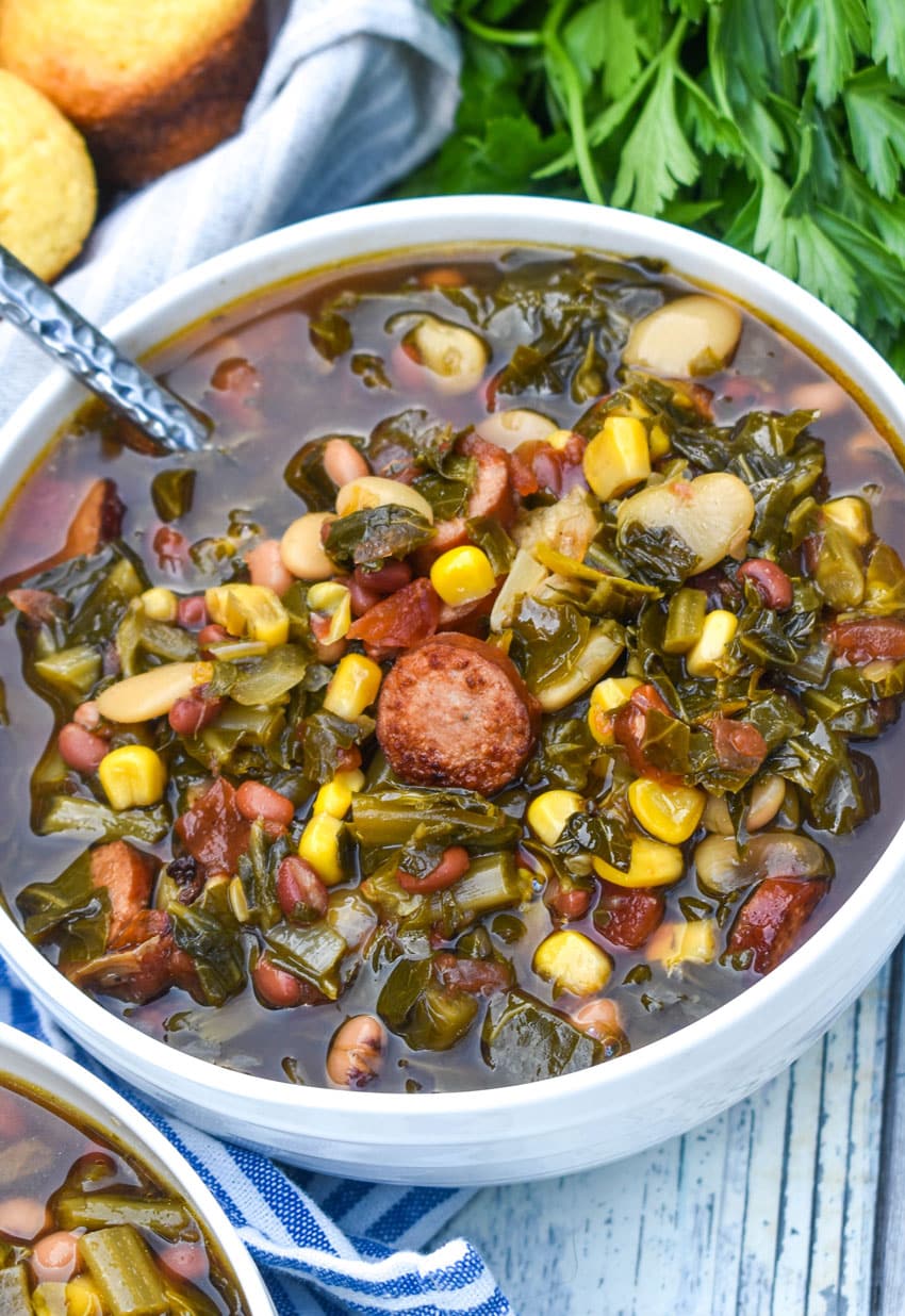 swamp soup in a white bowl with a silver spoon resting on the edge