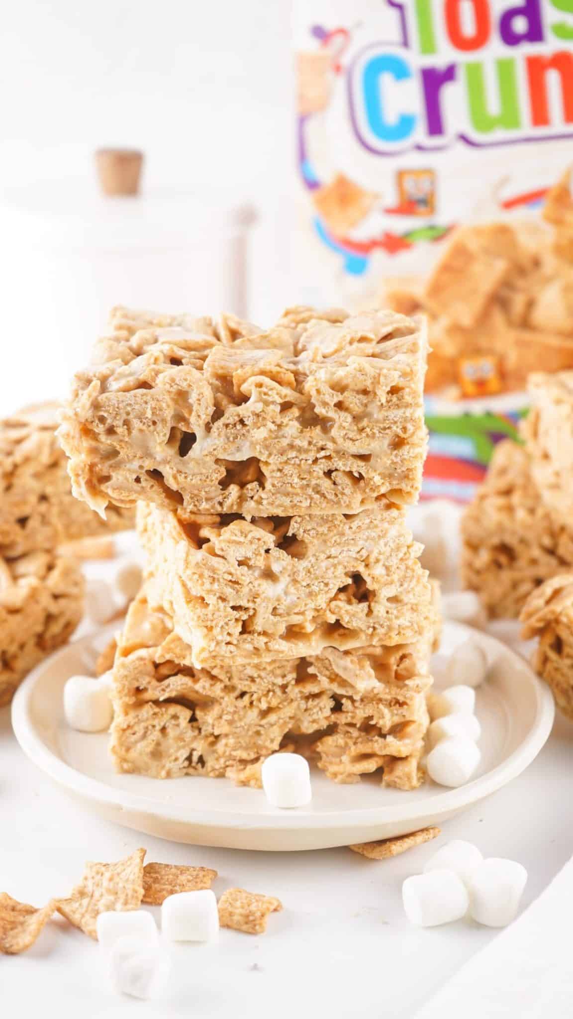 three homemade cinnamon toast crunch bars stacked on a small white dessert plate