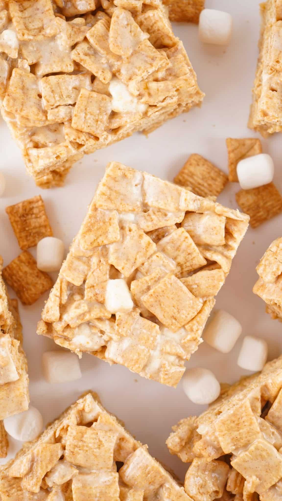 cinnamon toast crunch treats on small white dessert plate with mini marshmallows in the background
