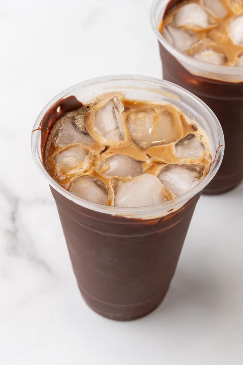 cold coffee over ice in a plastic cup lined with chocolate