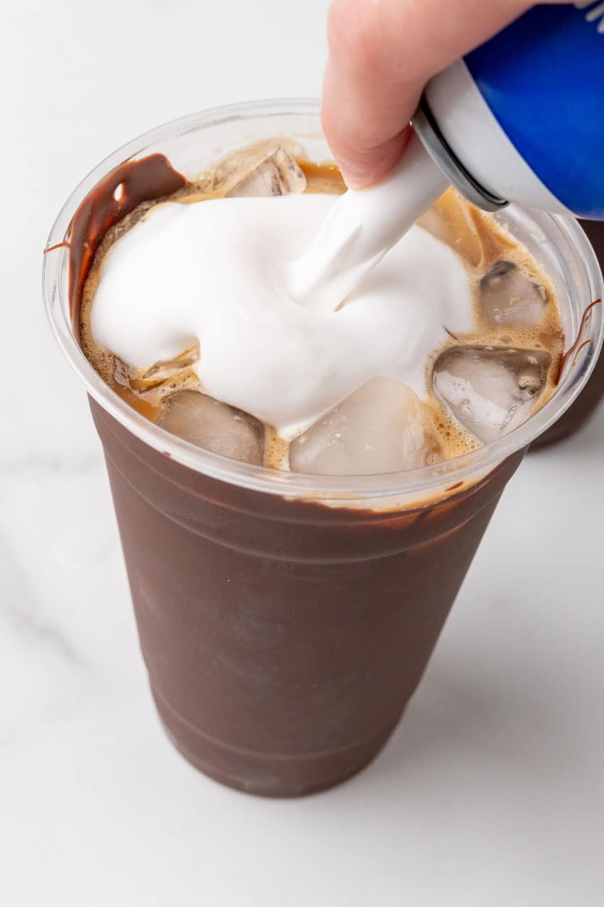 cold coffee over ice in a plastic cup lined with chocolate