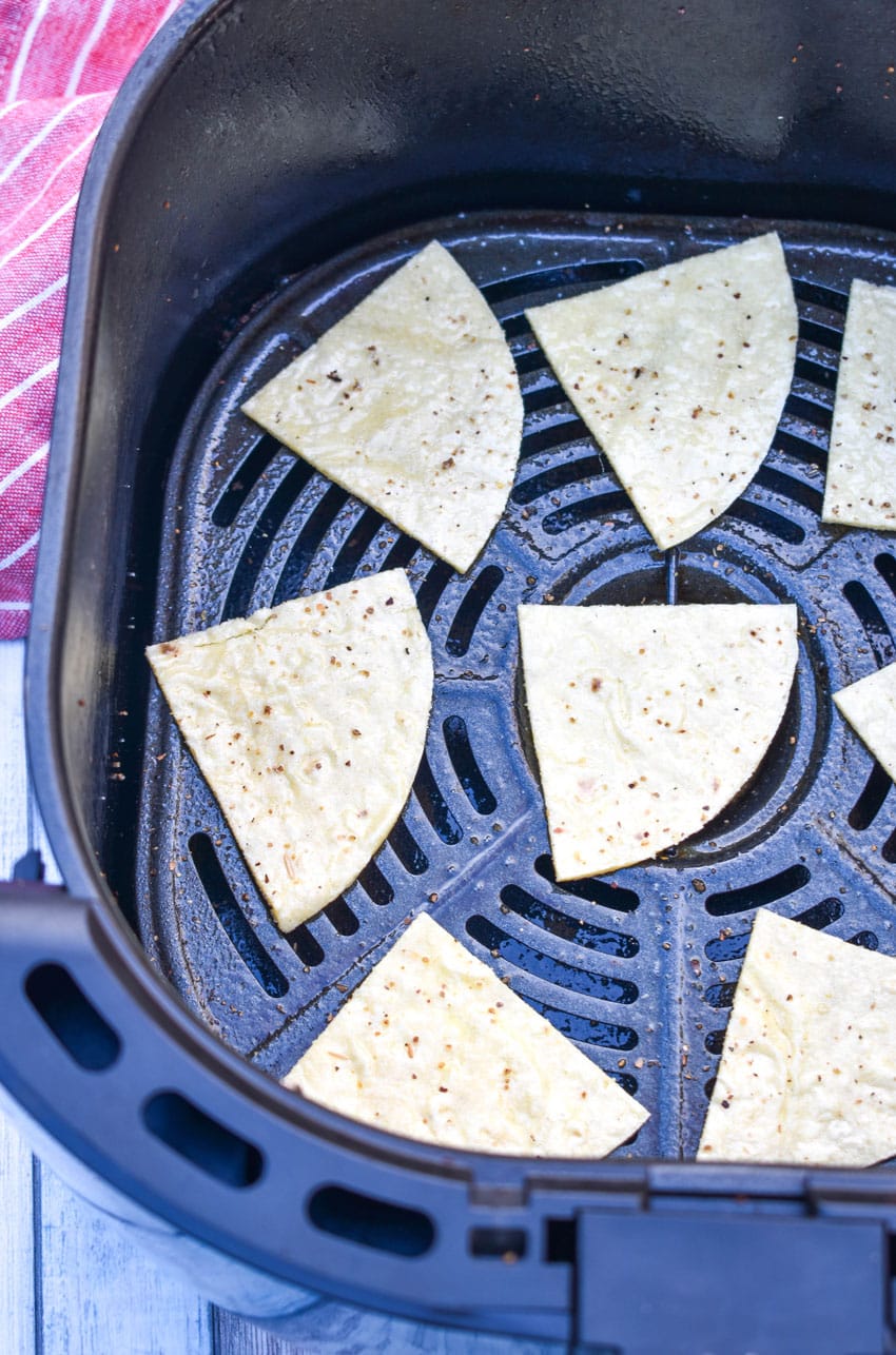 corn tortilla triangles in the basket of an air fryer