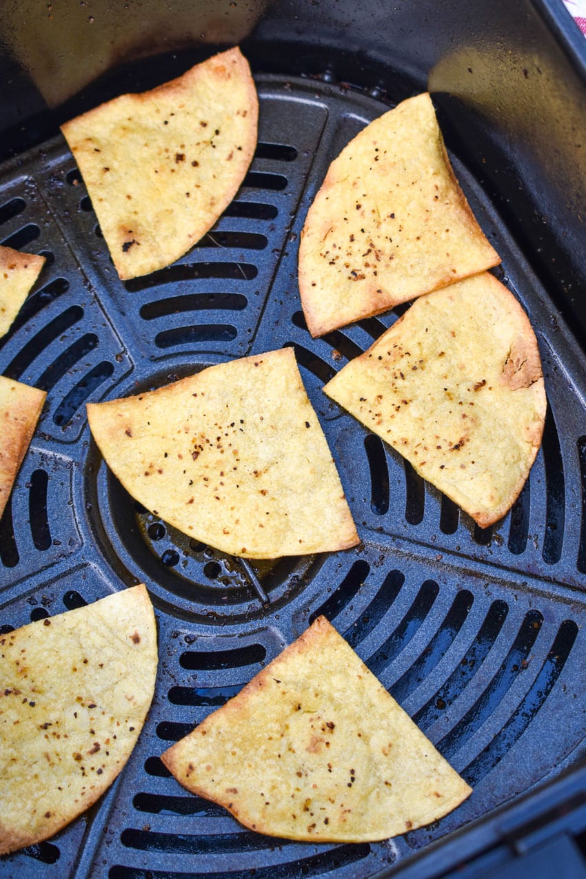 air fried corn tortillas in the basket of an air fryer
