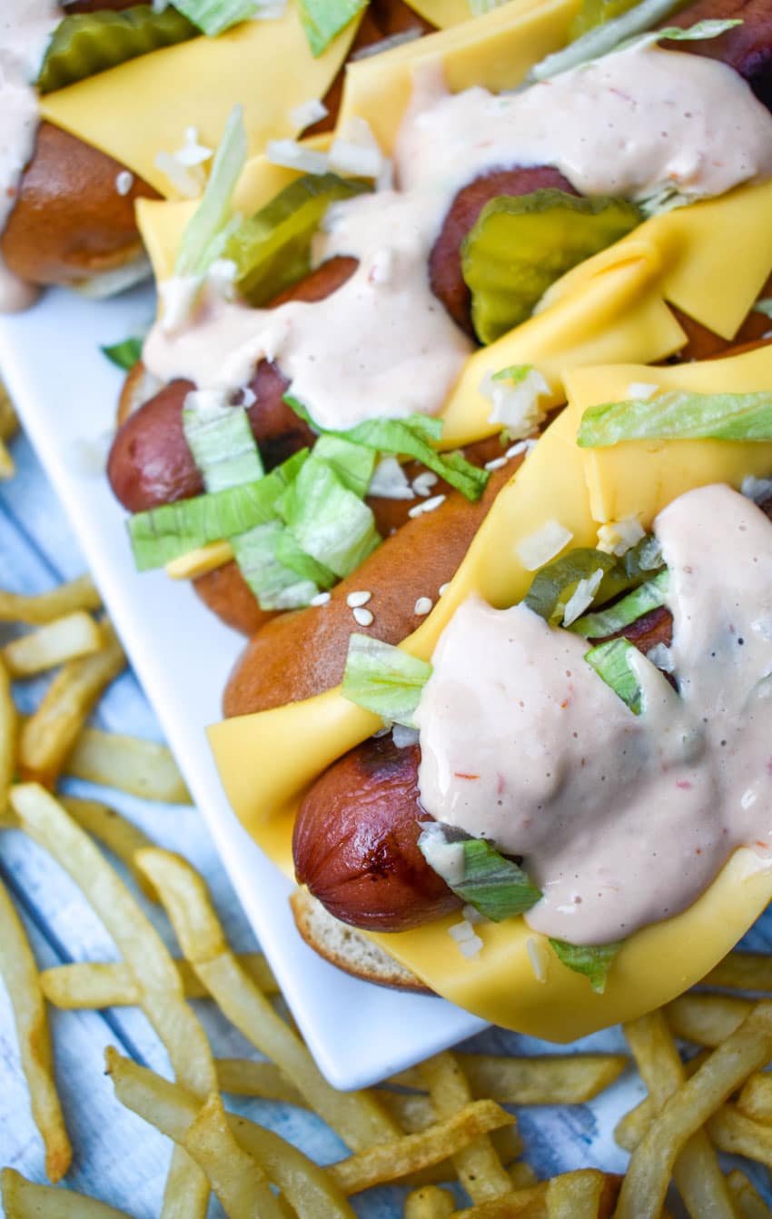 big mac hot dogs arranged in a row on a white serving platter