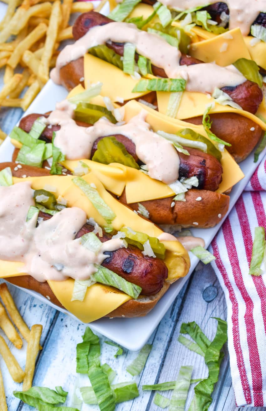 big mac hot dogs arranged in a row on a white serving platter