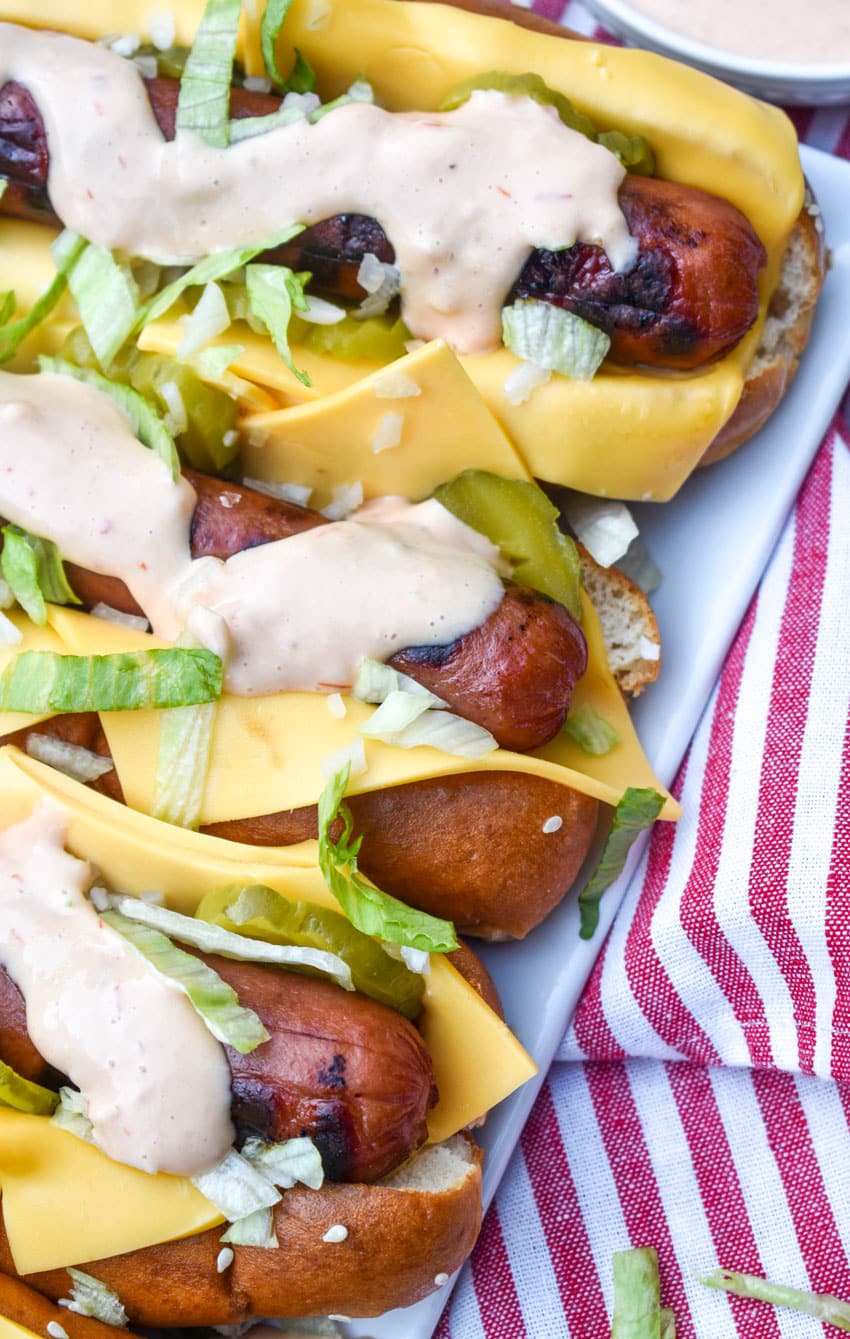 big mac hot dogs arranged in a row on a white serving platter