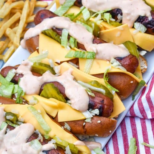 big mac hot dogs arranged in a row on a white serving platter