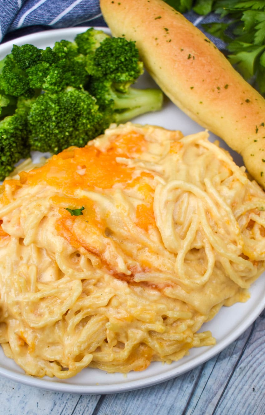 Spaghetti Mac & Cheese spaghetti mac and cheese on a white plate with a fresh breadstick on the side