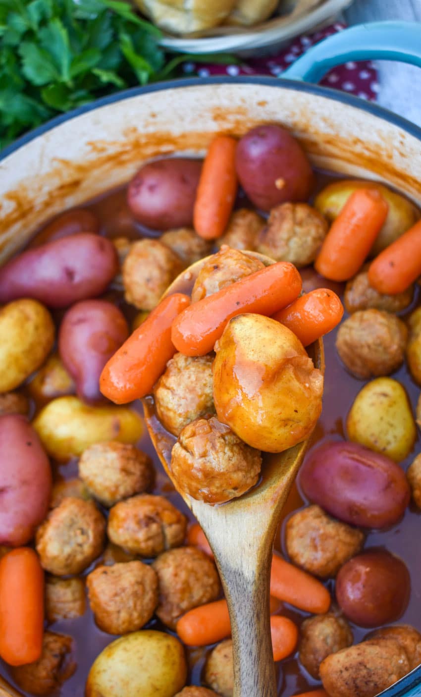 a wooden spoon holding up a scoop of meatball pot roast