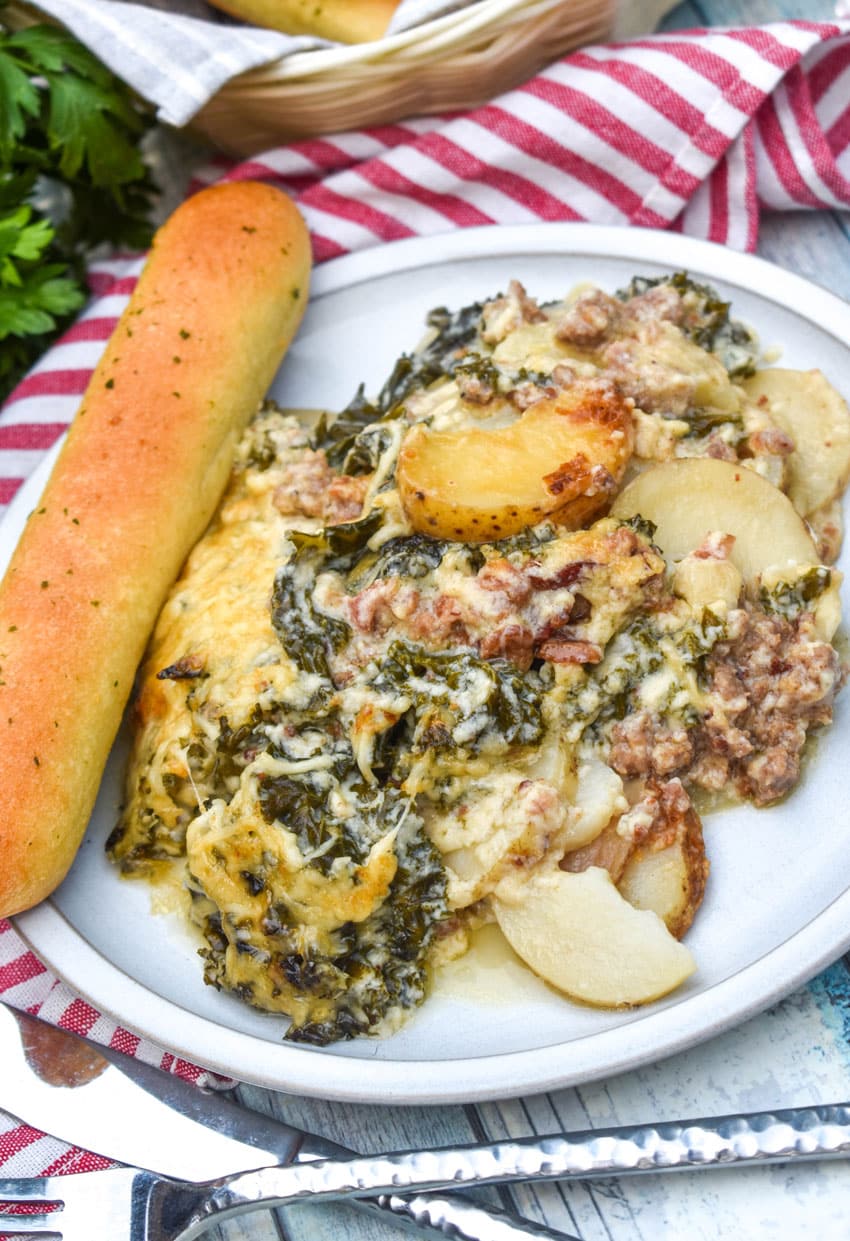 Zuppa Toscana Casserole zuppa toscana casserole on a white dinner plate with a breadstick on the side