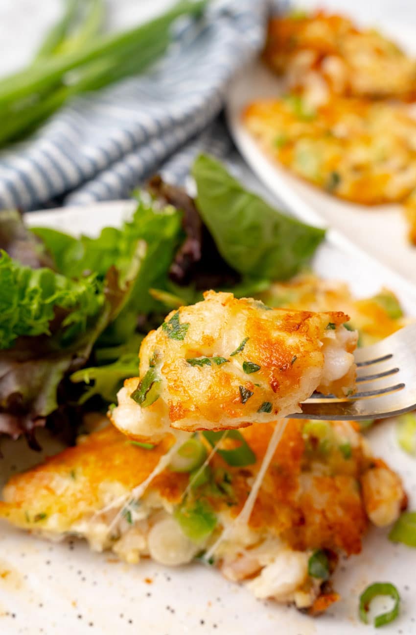 a silver fork holding up a piece of a shrimp fritter