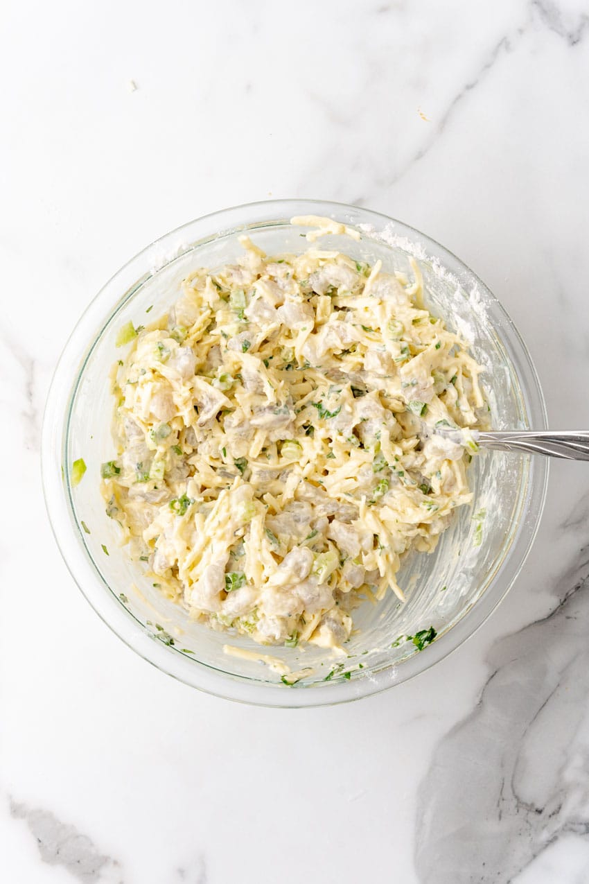 shrimp fritter batter stirred together in a glass mixing bowl