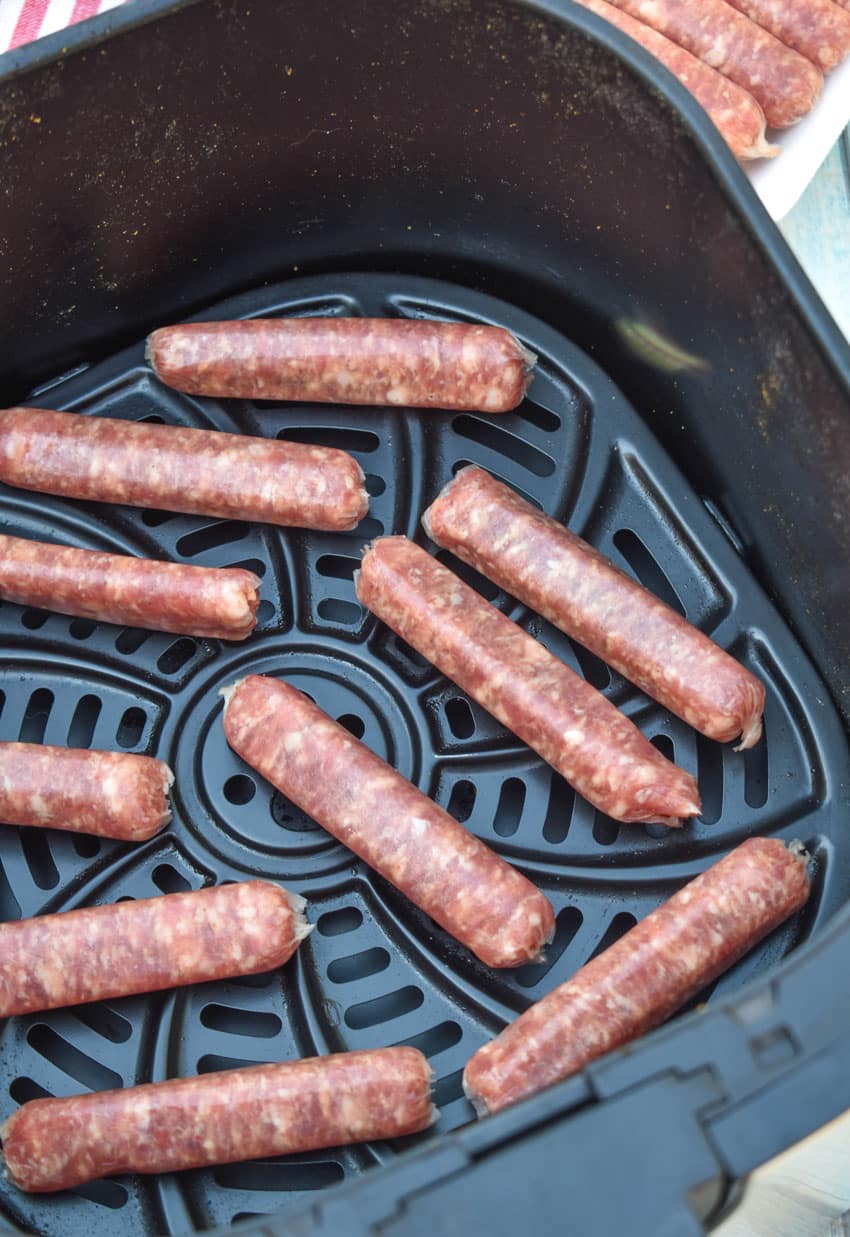 uncooked breakfast sausage in the basket of an air fryer