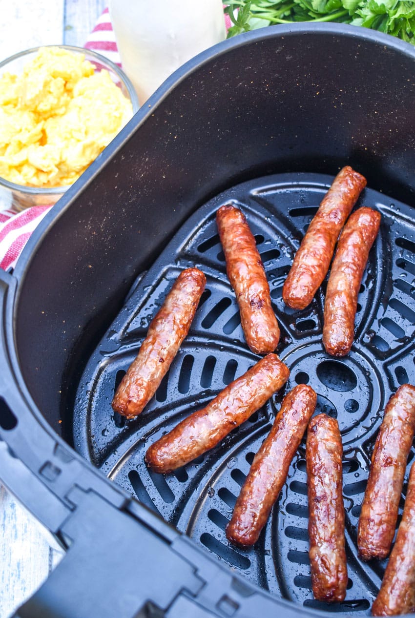 cooked breakfast sausage links in the basket of an air fryer