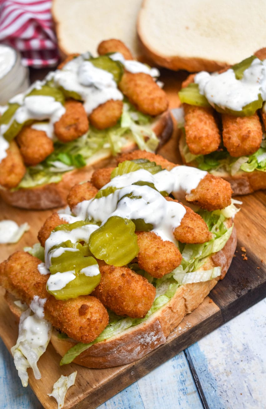 open face fish finger sandwiches on a wooden cutting board