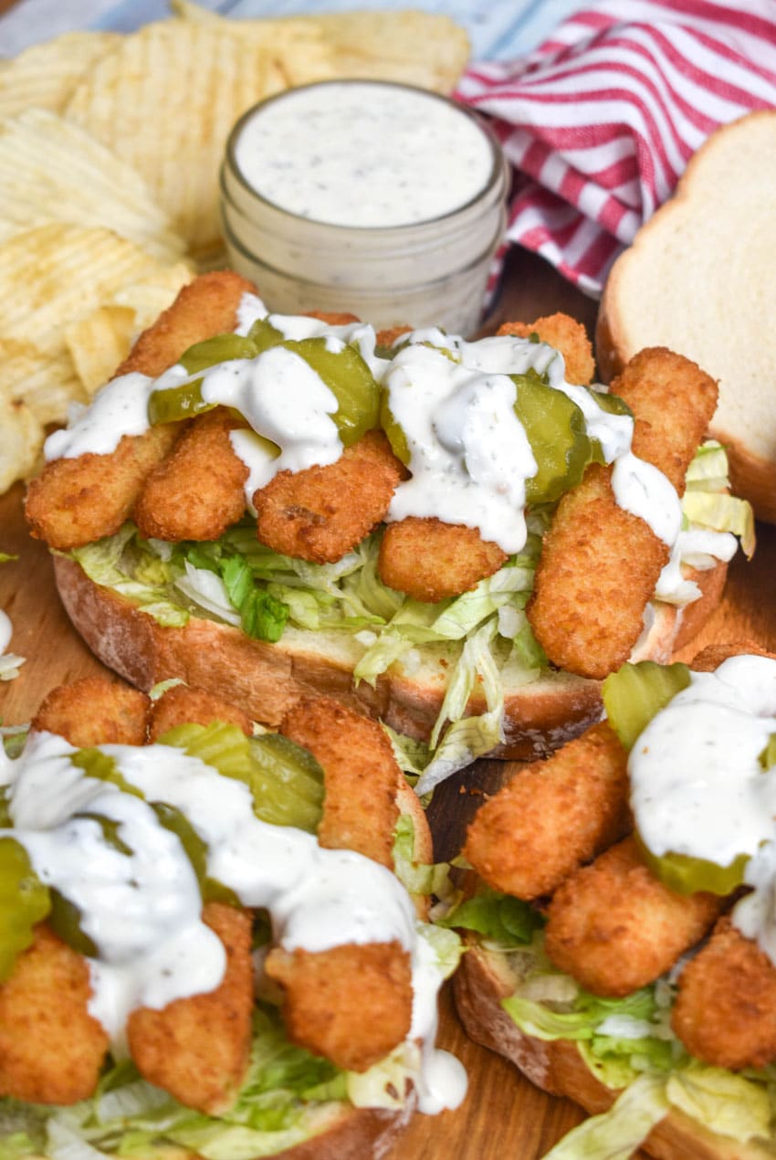 open face fish finger sandwiches on a wooden cutting board