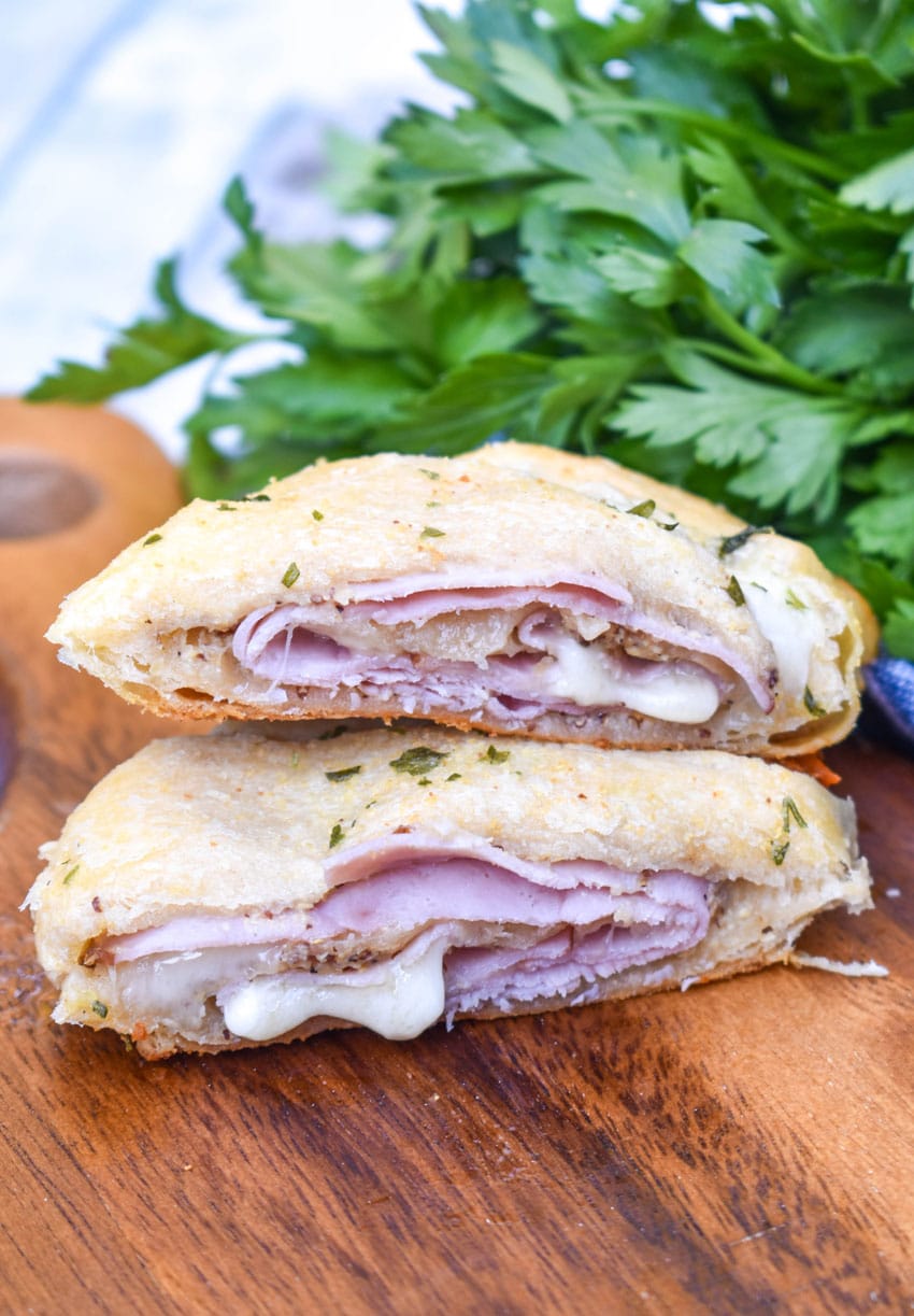 ham and cheese crescent rolls arranged on a wooden cutting board
