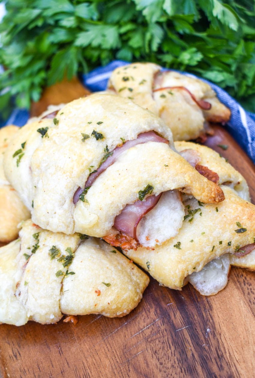 ham and cheese crescent rolls arranged on a wooden cutting board