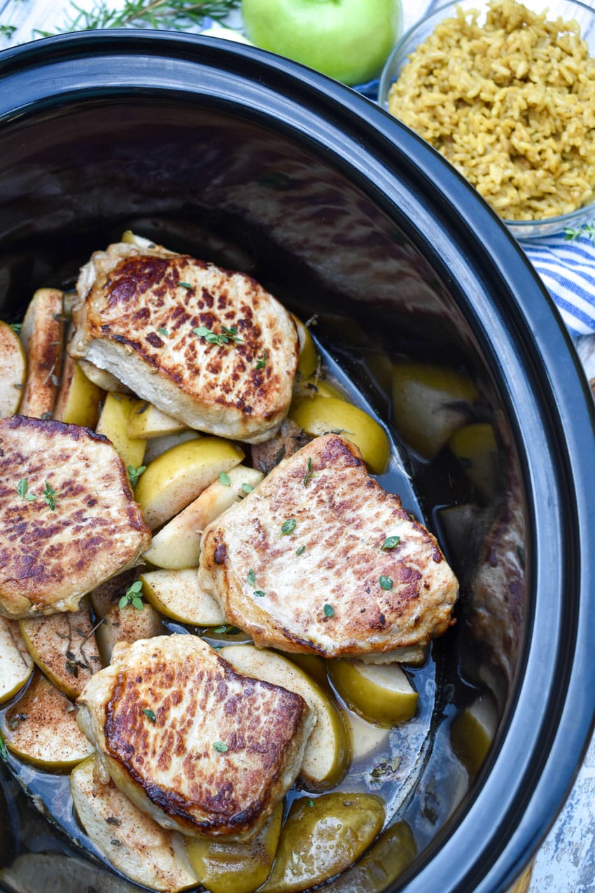 slow cooker pork chops and apples in a black crock