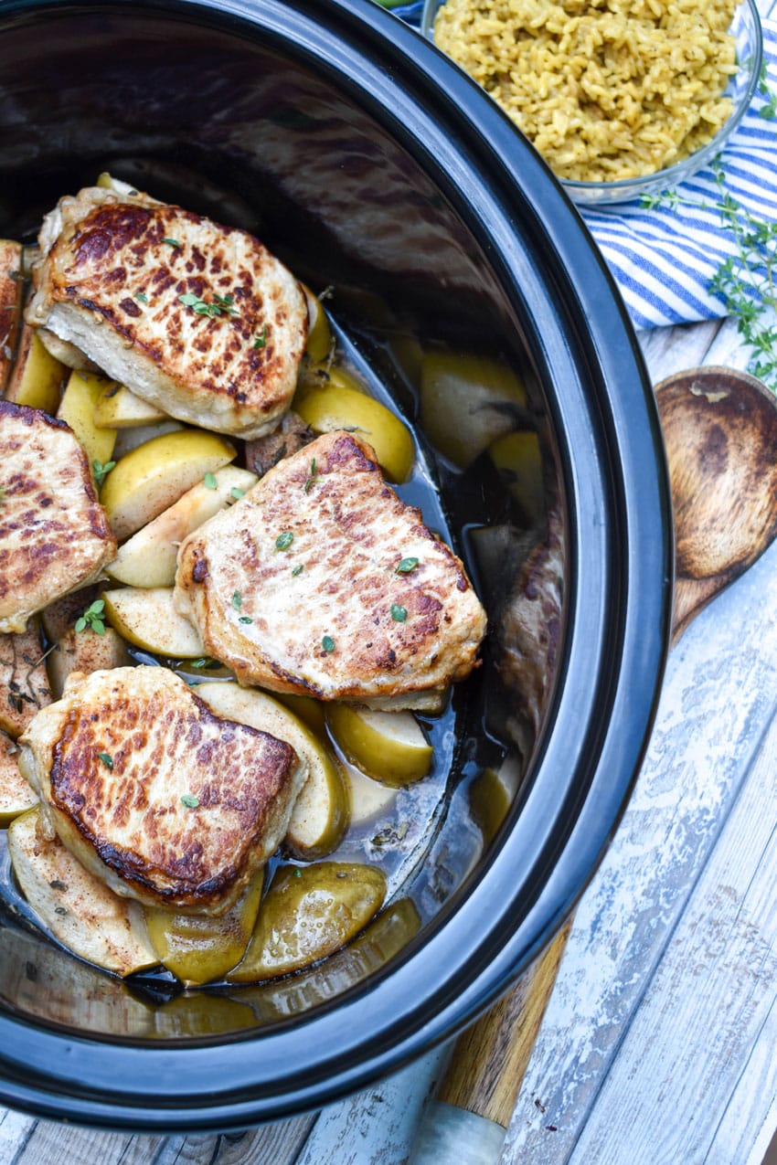 slow cooker pork chops and apples in a black crock
