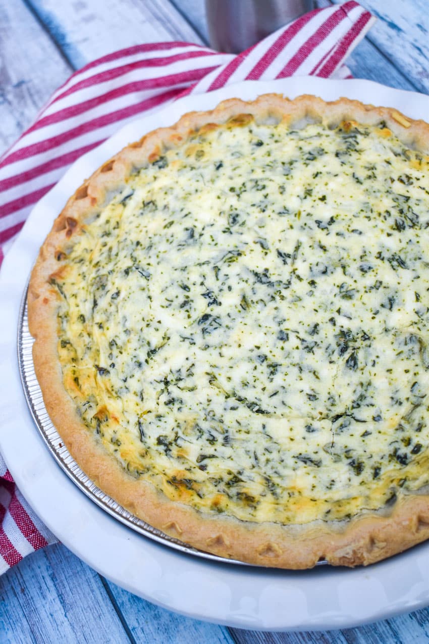 a creamed spinach pie in a white pie plate