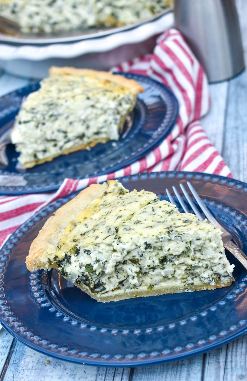 slices of creamed spinach pie on two small blue plates