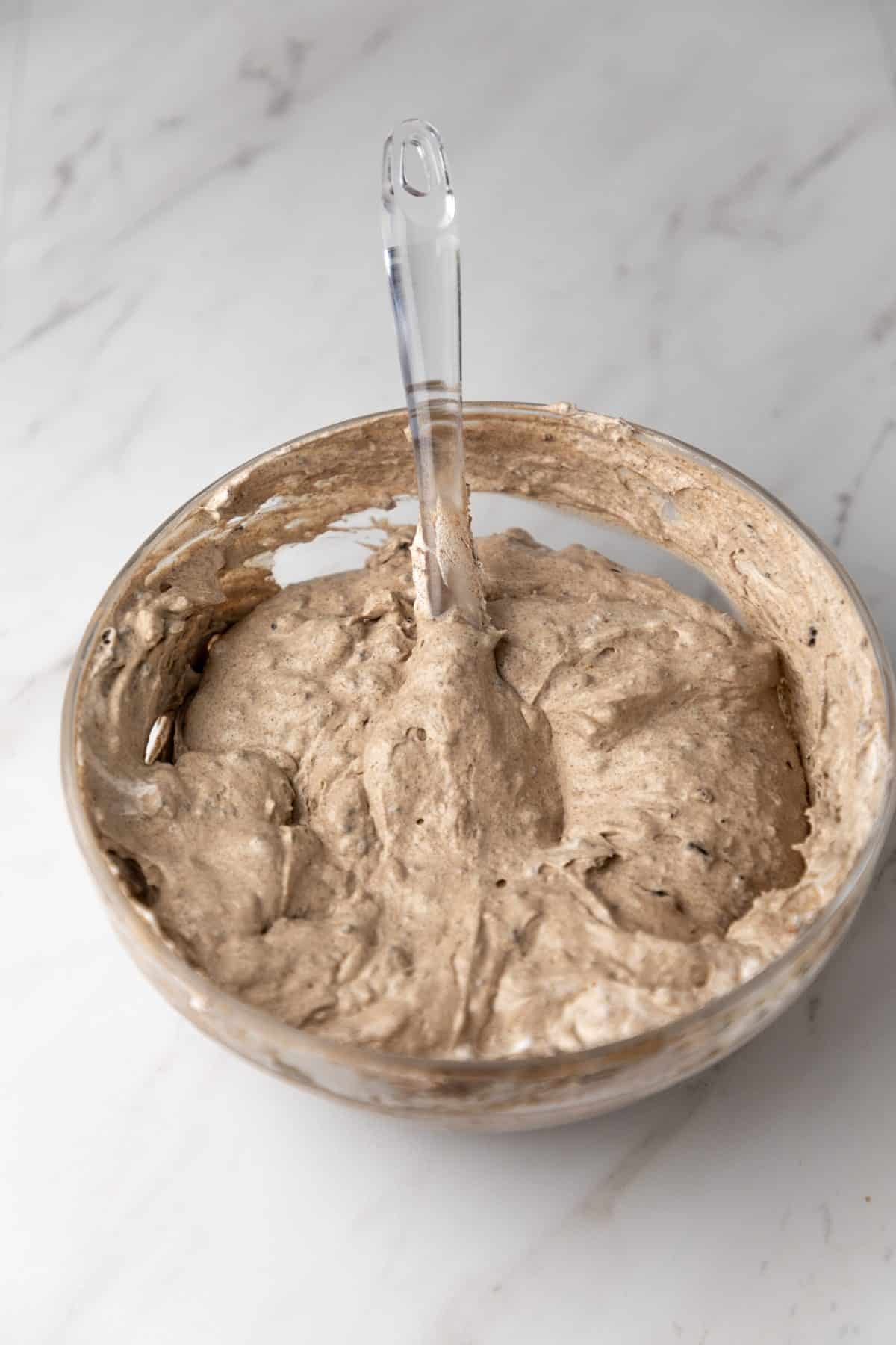 the grey stuff oreo pudding in a large glass mixing bowl