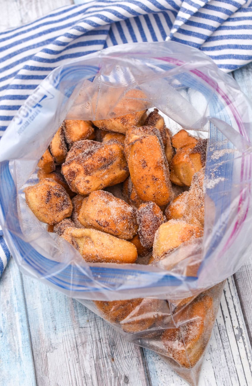cinnamon roll bites tossed in cinnamon and sugar in a large ziplocking bag