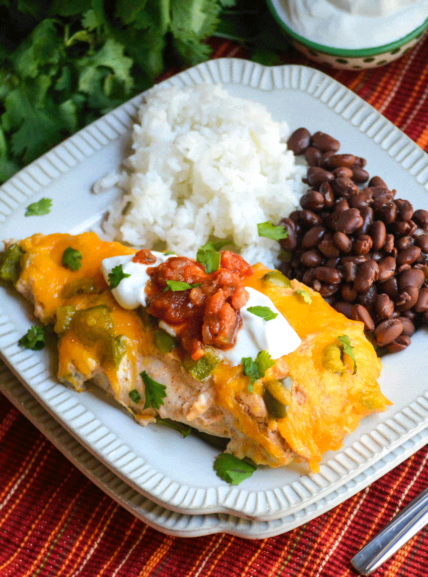 baked cheesy fajita chicken next to steamed white rice and black beans on a small square white plate