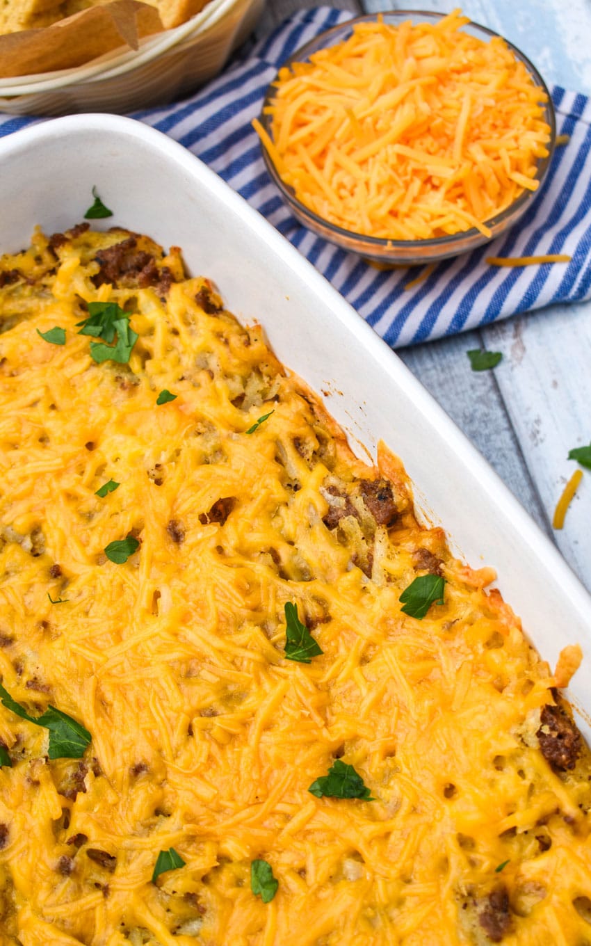 cheesy hash brown casserole with ground beef in a large white baking dish