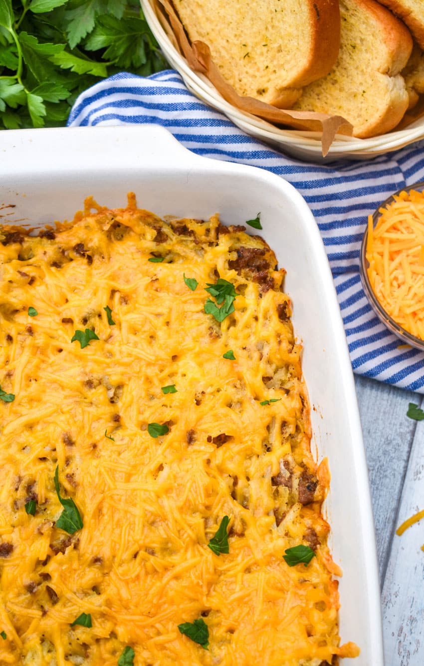 cheesy hash brown casserole with ground beef in a large white baking dish