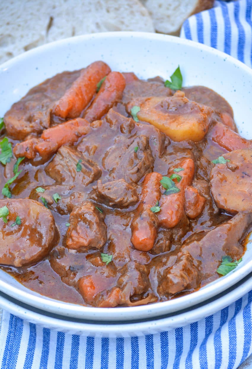 french onion beef stew in a shallow white bowl