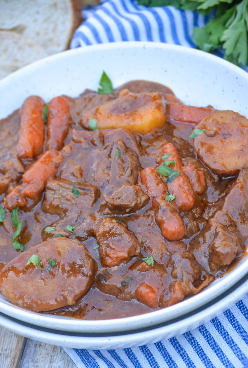 french onion beef stew in a shallow white bowl