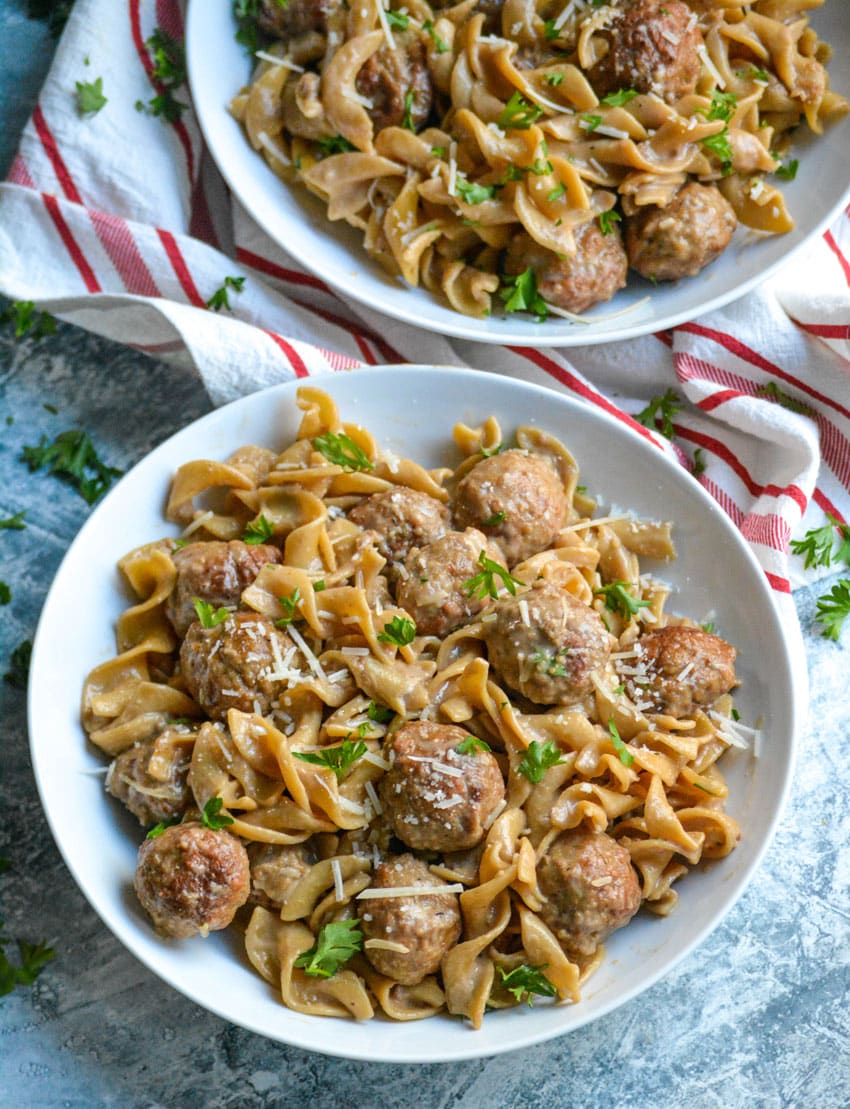 one pot swedish meatball topped with fresh herbs in two shallow white bowls