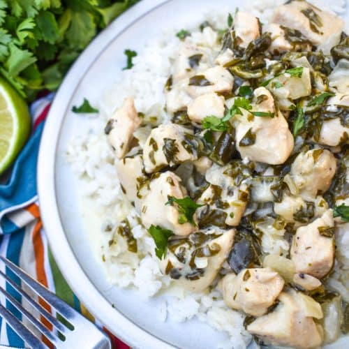 CREAMY POBLANO CHICKEN OVER STEAMED WHITE RICE ON A WHITE PLATE