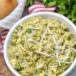 pesto chicken salad topped with shredded parmesan cheese in a white bowl