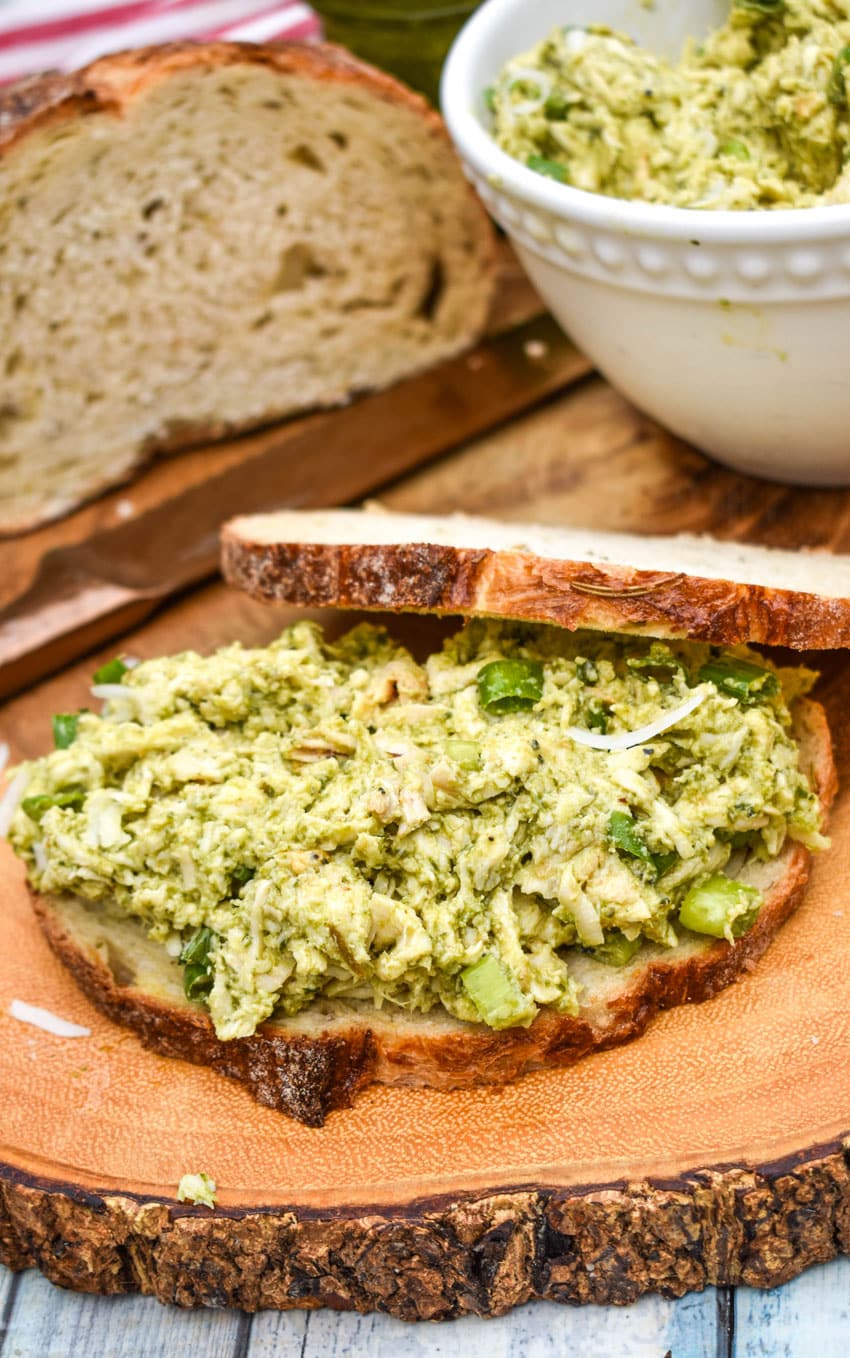 pesto chicken salad spread on a slice of pesto bread