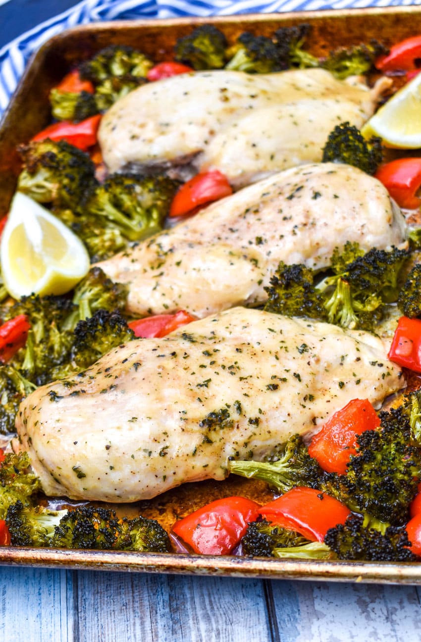 sheet pan lemon chicken and roasted vegetables on a metal baking pan